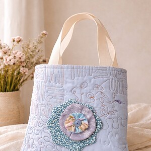 Beautifully Pastel Bloom Handmade Cotton Tote 100% cotton tote featuring a delicate layered flower appliqué and decorative quilting. Fully lined with pure cotton and finished with strong durable handles. Fully washable and tumble dry safe